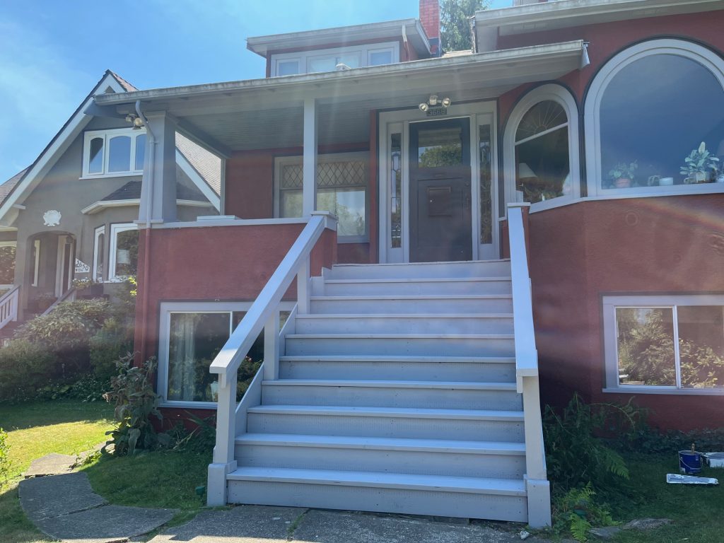 Freshly painted front exterior stairs and entry railings in crisp white on a character home in Port Moody